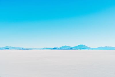 Scenic view of desert against clear blue sky