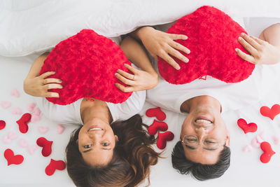 High angle view portrait of friends lying on bed