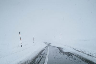 Road leading towards snow covered landscape