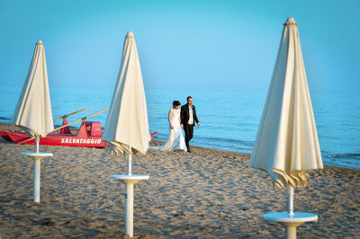 People at beach against sky