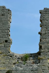 Low angle view of old ruins against clear blue sky