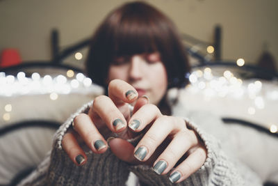 Close-up portrait of young woman holding hands