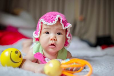 Portrait of cute baby girl with toy at home