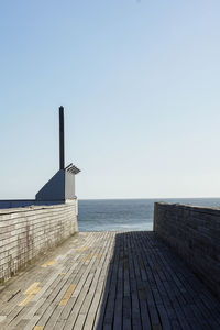 Pier over sea against clear sky