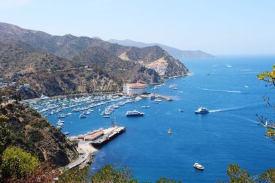 Boats in calm sea with mountain range in background