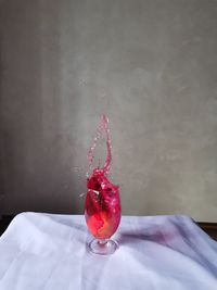 Close-up of red berries on glass against table