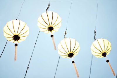 Low angle view of lanterns hanging against clear sky