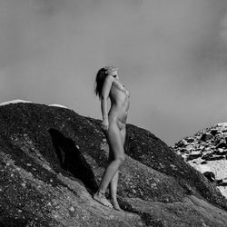 Woman standing on rock against sky