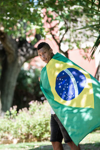 Portrait of man with brazilian flag outdoors