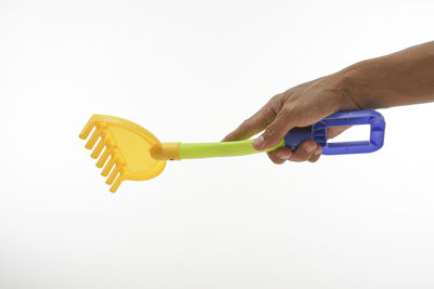 Close-up of hand holding umbrella against white background