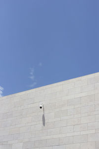 Low angle view of wall against blue sky