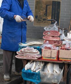 Midsection of man working at market stall