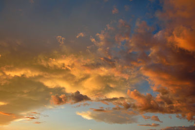 Colorful altocumulus clouds on blue sky background with sunrise.