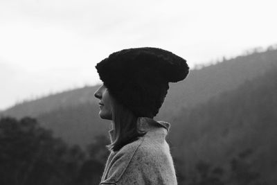 Woman in knit hat against mountains