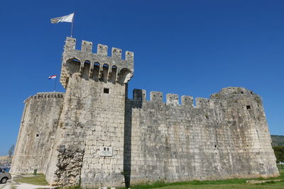 Low angle view of old ruins against clear blue sky