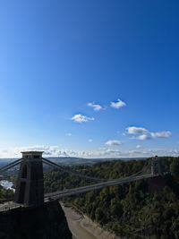 Road by bridge against blue sky