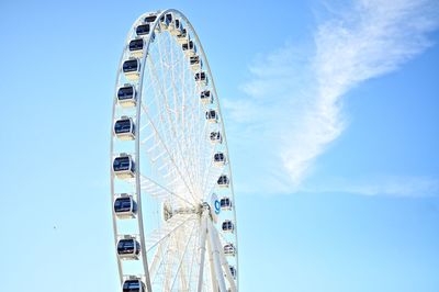 Low angle view of ferris wheel against blue sky