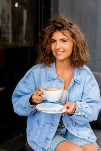 Portrait of young woman drinking coffee