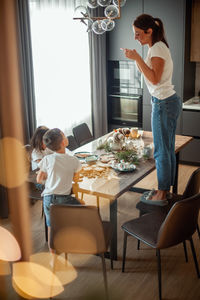 Woman standing by table at home