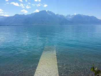 Scenic view of sea and mountains against sky