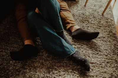 Low section of people sitting on rug