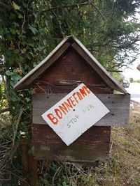 Close-up of sign board on tree