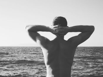 Man standing on beach against clear sky