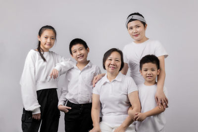 Portrait of a smiling friends standing against gray background