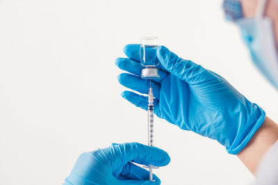 Midsection of person holding blue ring against white background