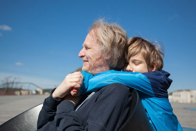 Portrait of father and son against blue sky