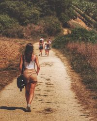 Full length rear view of woman walking on pathway during sunny day