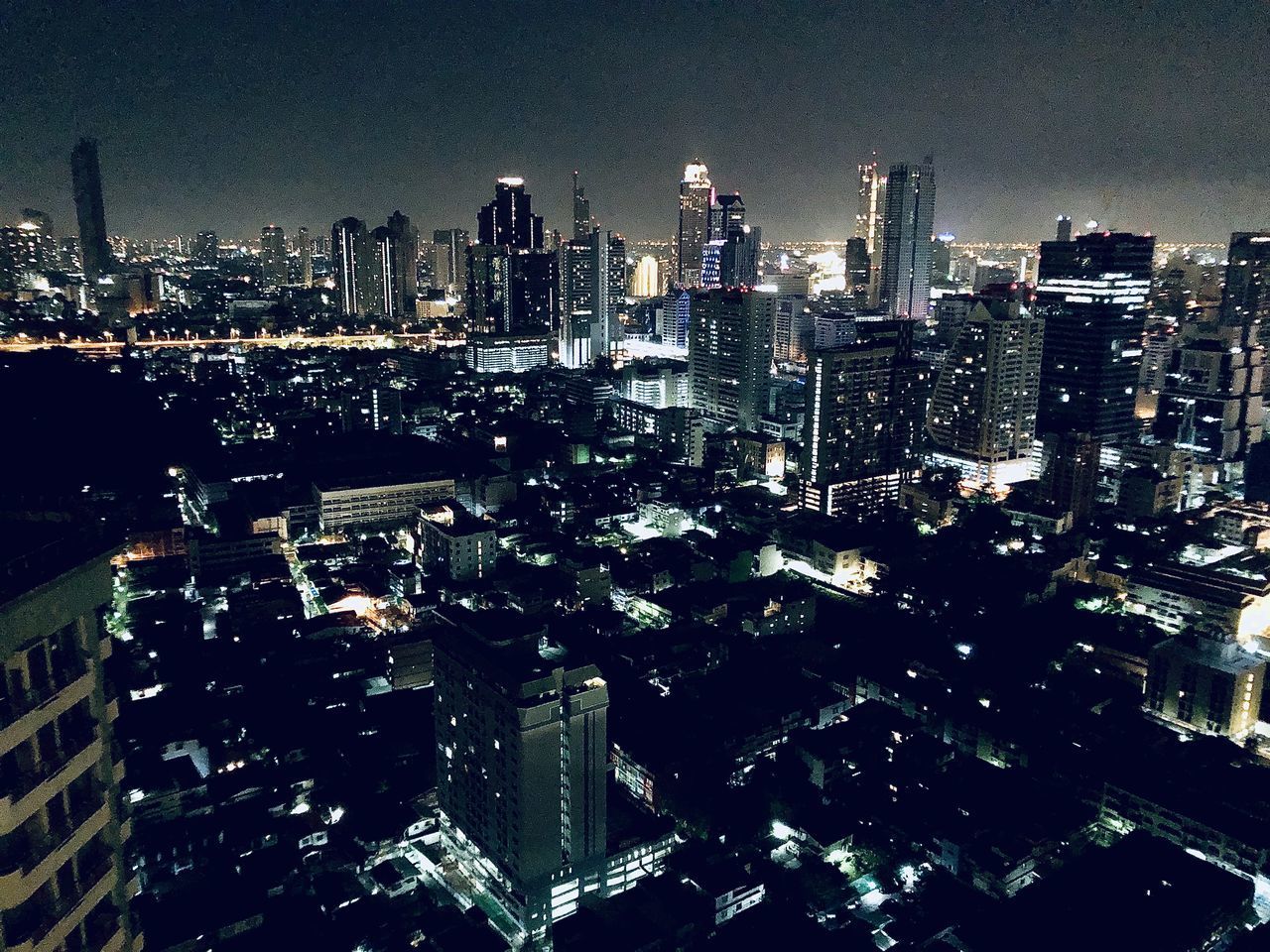 AERIAL VIEW OF ILLUMINATED CITY BUILDINGS AT NIGHT