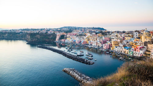 High angle view of townscape by sea against sky