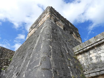 Low angle view of old building against cloudy sky