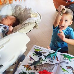 Cute boy playing to toys besides sleeping