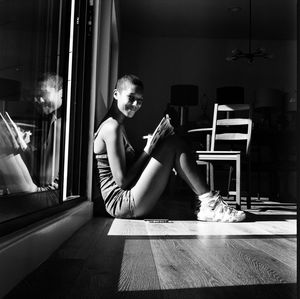 Portrait of woman sitting on table at home