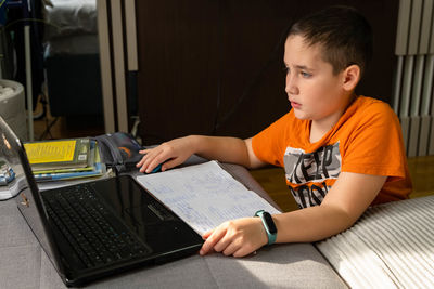 Boy using laptop during online learning