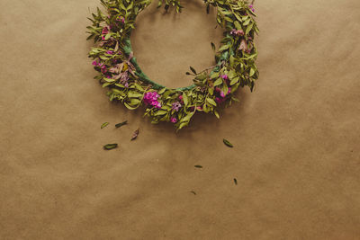 High angle view of floral wreath on brown paper