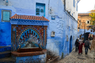 People walking on street amidst buildings in town