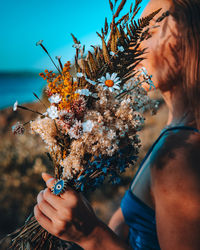 Close-up of woman holding flowering plant