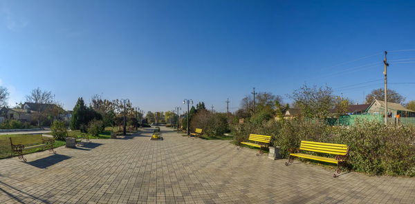 Panoramic view of yellow tracks against clear blue sky