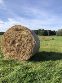 Hay bales on field against sky