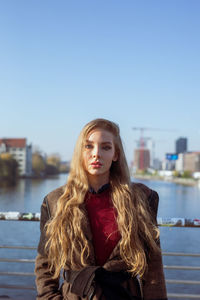 Portrait of beautiful young woman against sky