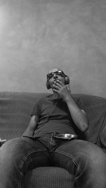 Man smoking cigarette while sitting on couch