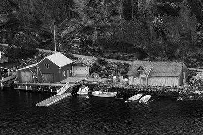 Houses by river against buildings