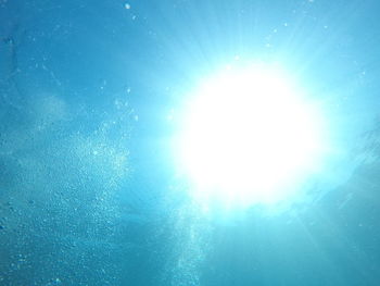 Low angle view of blue sea on sunny day