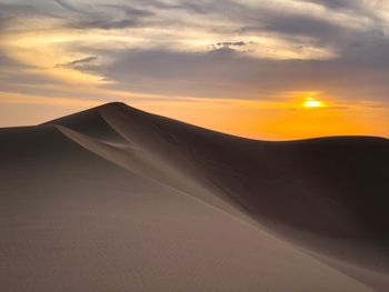 Scenic view of desert against sky during sunset