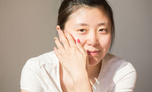 Close-up portrait of woman against wall