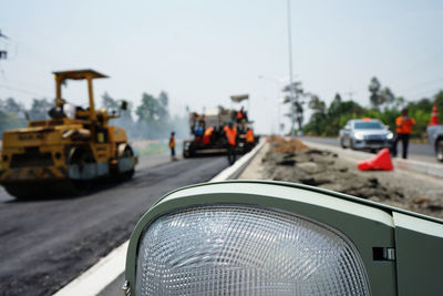 Vehicles on road against sky in city