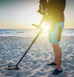 Man with a metal detector on a sea sandy beach